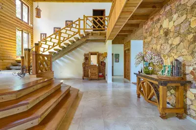 a large room with a staircase and a stone wall at ®4BR{Wood~Mountain~Villa} @Jarabacoa Heated Pool in Jarabacoa