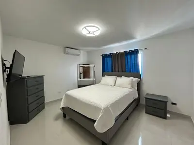 a bedroom with a bed and a television in it at Luxury Pool Gym Basketball in Santiago de los Caballeros