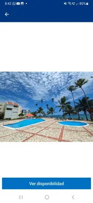 a screenshot of a website with a picture of a swimming pool at Atardecer Albatros in Juan Dolio