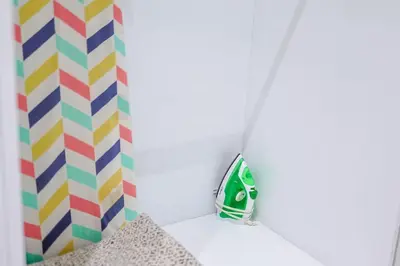 a bathroom with a green and colorful shower curtain at Cozy 1BR Condo, Pool, Gym in Santo Domingo