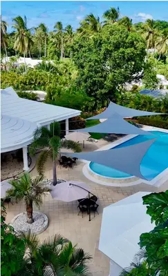 a resort with a pool and tables and umbrellas at La Pala Suites in Las Terrenas