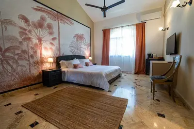 a bedroom with a bed and a large painting on the wall at La Pala Suites in Las Terrenas