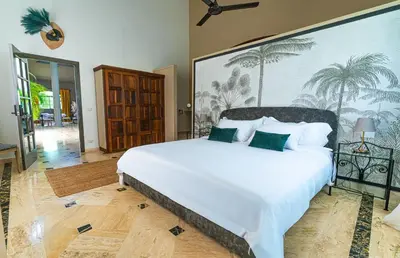 a bedroom with a large white bed with green pillows at La Pala Suites in Las Terrenas