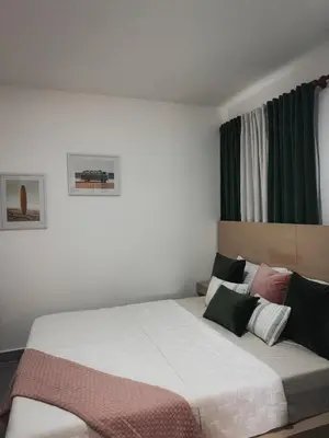 a bedroom with a large bed with green curtains at Amor in Punta Cana
