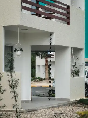 a white building with a entrance to a parking lot at Amor in Punta Cana