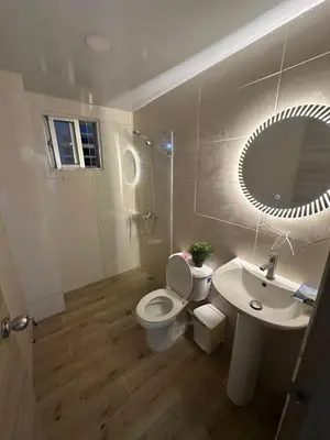 a bathroom with a toilet and a sink and a mirror at Apartamento deluxes en Bonao in Bonao