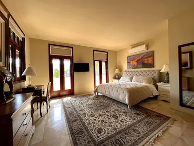 a large bedroom with a bed and a desk and a desk at Lux 2-Level Townhouse with Stunning Historic Views in Santo Domingo