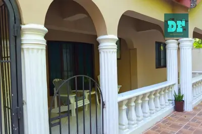 a balcony with white columns and a table on a porch at Villa Eli in Puerto Plata