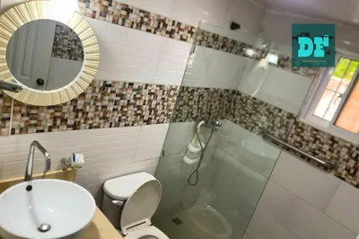 a bathroom with a toilet and a sink and a mirror at Villa Eli in Puerto Plata