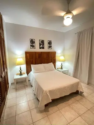 a bedroom with a bed and two lamps on two tables at Apartment 5 Mins Walk To The Beach