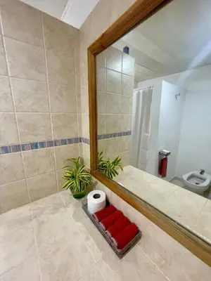 a bathroom with a large mirror and a toilet at Apartment 5 Mins Walk To The Beach