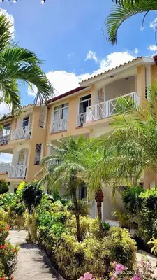 a building with palm trees in front of it at Apartment 5 Mins Walk To The Beach