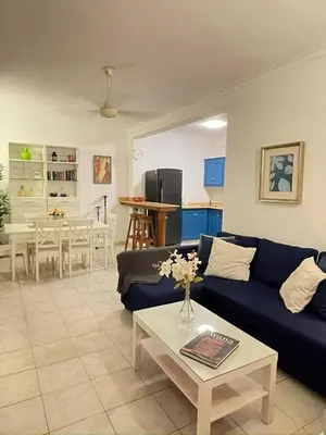 a living room with a blue couch and a table at Apartment 5 Mins Walk To The Beach