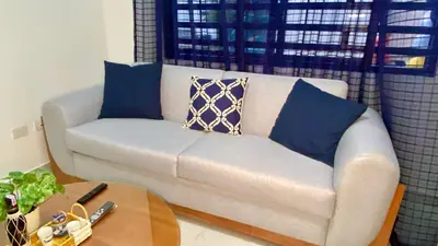 a white couch with blue pillows in a living room at Zarzuela Villas del Mar Puerto Plata in Muñoz
