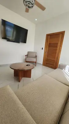 a living room with a couch and a table and a tv at Zarzuela Villas del Mar Puerto Plata in Muñoz