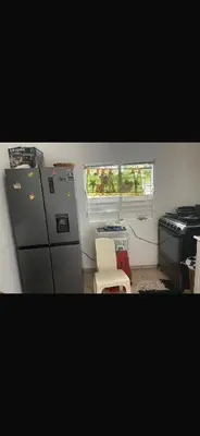 a kitchen with a refrigerator and a stove and a window at santo domingo airport villa in Reparto Esther Rosario