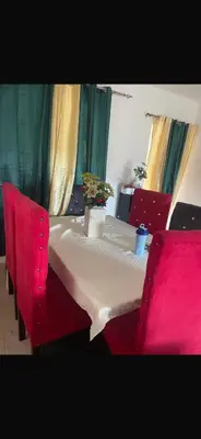 a table with red chairs and a table with a white table cloth at santo domingo airport villa in Reparto Esther Rosario