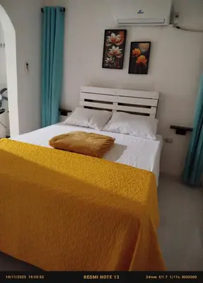 a bedroom with a bed with a yellow blanket on it at Hotel El Almendro in Pedernales
