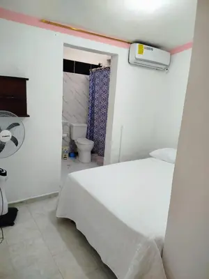 a bedroom with a white bed and a toilet at Hotel El Almendro in Pedernales