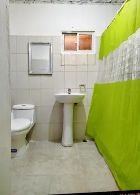 a bathroom with a sink and a toilet and a window at Hotel El Almendro in Pedernales