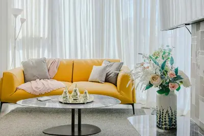 a living room with a yellow couch and a table at Chic Elegant City Center Condo in Santo Domingo