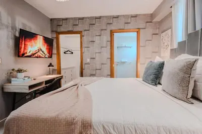 a bedroom with a large white bed and a desk at Chic Elegant City Center Condo in Santo Domingo
