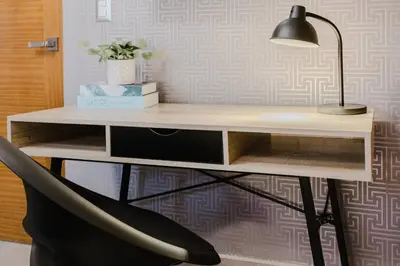 a desk with a lamp and a black chair at Chic Elegant City Center Condo in Santo Domingo