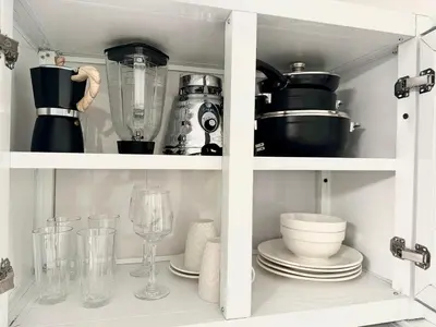 a kitchen cabinet filled with dishes and a blender at RoblestRoom in Santiago de los Caballeros