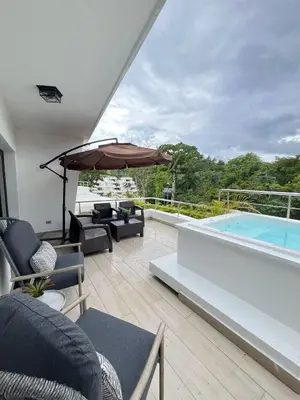 a patio with an umbrella and a swimming pool at apartamento exclusivo con jacuzzi, piscina y vista al lago in Las Terrenas