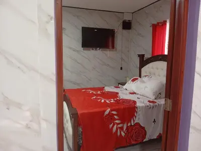 a bedroom with a bed with a red and white blanket at Villa colombia in Miches