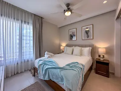 a bedroom with a large bed and a window at Beautiful brand new Beach Condo w Picuzzi in Punta Cana