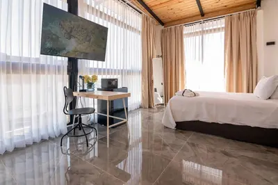 a bedroom with a bed and a desk in a room at Casa Ola & Surf in San Felipe de Puerto Plata