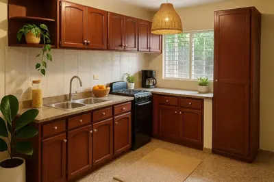 a kitchen with wooden cabinets and a sink at Bright & Spacious En-suite Room - Santo Domingo Este in Cancino