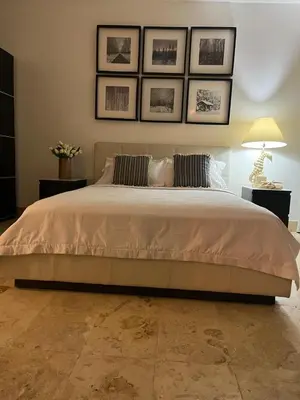 a bedroom with a large bed with pictures on the wall at Antiguo Dominican Bay in Cuevas