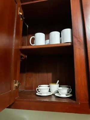 a shelf with cups and saucers in a cabinet at Espacioso Casa en Puerto Plata cerca de La Playa 4 camas 3 baños Agua caliente Aire condicionado Wi-Fi in Puerto Plata