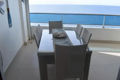 a dining table and chairs with a view of the ocean at El Sueño, Breathtaking Ocean Front, Juan Dolio in Guayacanes