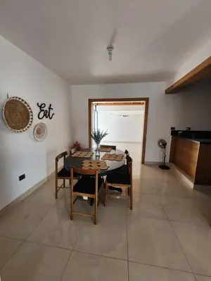 a dining room with a table and chairs and a piano at Cerro hermoso in Santiago de los Caballeros