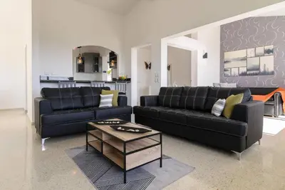 a living room with two black couches and a coffee table at Casa Mango- Relax - Pool Stunning Views in San Felipe de Puerto Plata