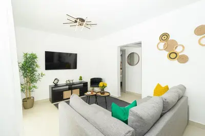 a living room with a couch and a tv at Coastal Comfort in Bayahibe 2BR 2BA Carribean Rose in San Rafael del Yuma