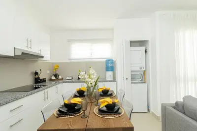 a kitchen with a wooden table with a vase of flowers on it at Coastal Comfort in Bayahibe 2BR 2BA Carribean Rose in San Rafael del Yuma