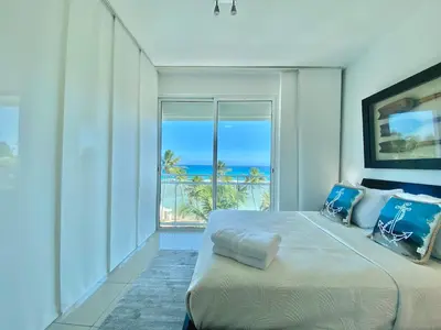 a bedroom with a bed with a view of the ocean at Cozy Beach Front Condo, Pool in La Puntica de Juan Dolio