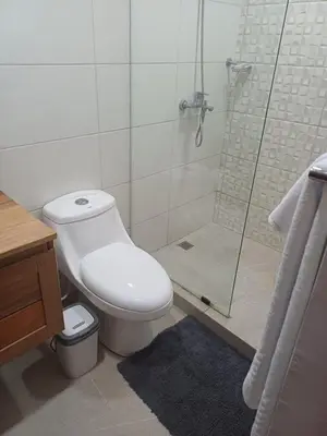 a bathroom with a toilet and a glass shower at Sunset Apartment Beach Residences Steps from the Beach in Puerto Plata