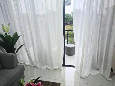 a living room with white curtains and a window at Sunrise Apartments in San Felipe de Puerto Plata