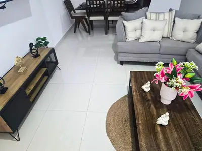 a living room with a couch and a table with flowers at Sunrise Apartments in San Felipe de Puerto Plata