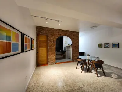 a room with a table and chairs and a brick wall at Apartment in Zona Colonial in Santo Domingo