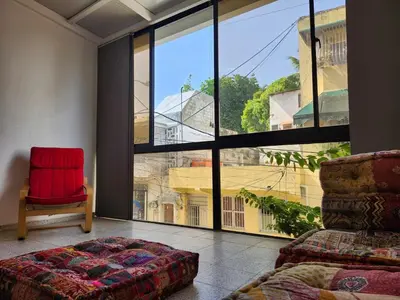 a bedroom with a red chair and a large window at Apartment in Zona Colonial in Santo Domingo