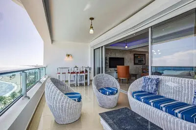 a living room with a couch and chairs on a balcony at Apartamento Hermoso Frente Al Mar 11fl Amanzing in Juan Dolio