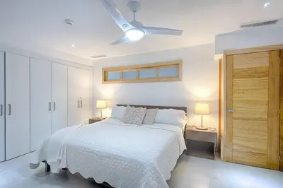 a bedroom with a white bed and a ceiling fan at Apartamento En Marbella Vista Al Mar in Villas del Mar