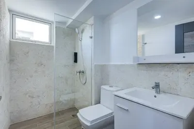 a bathroom with a toilet and a sink and a shower at Coralclifftower in Juan Dolio