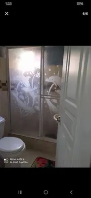 a bathroom with a toilet and a window with cars at Don Carlos Recidencia